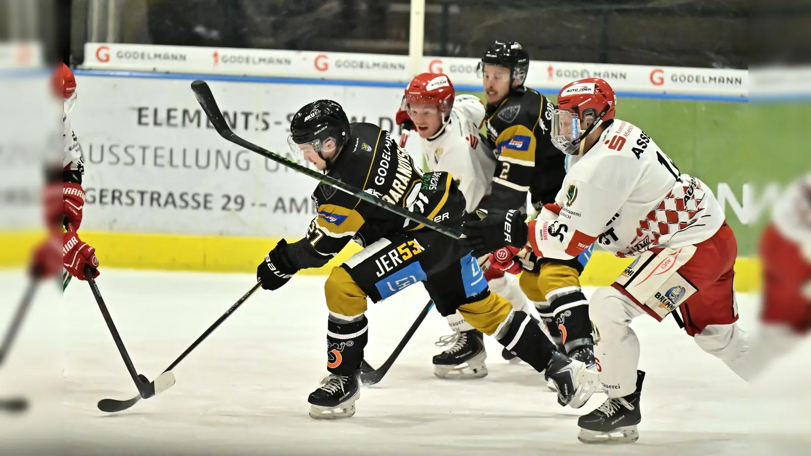 Roberts Baranovskis (Mitte) vom ERSC Amberg kann sich in dieser Szene an der Scheibe behaupten.  (Bild: Hubert Ziegler)