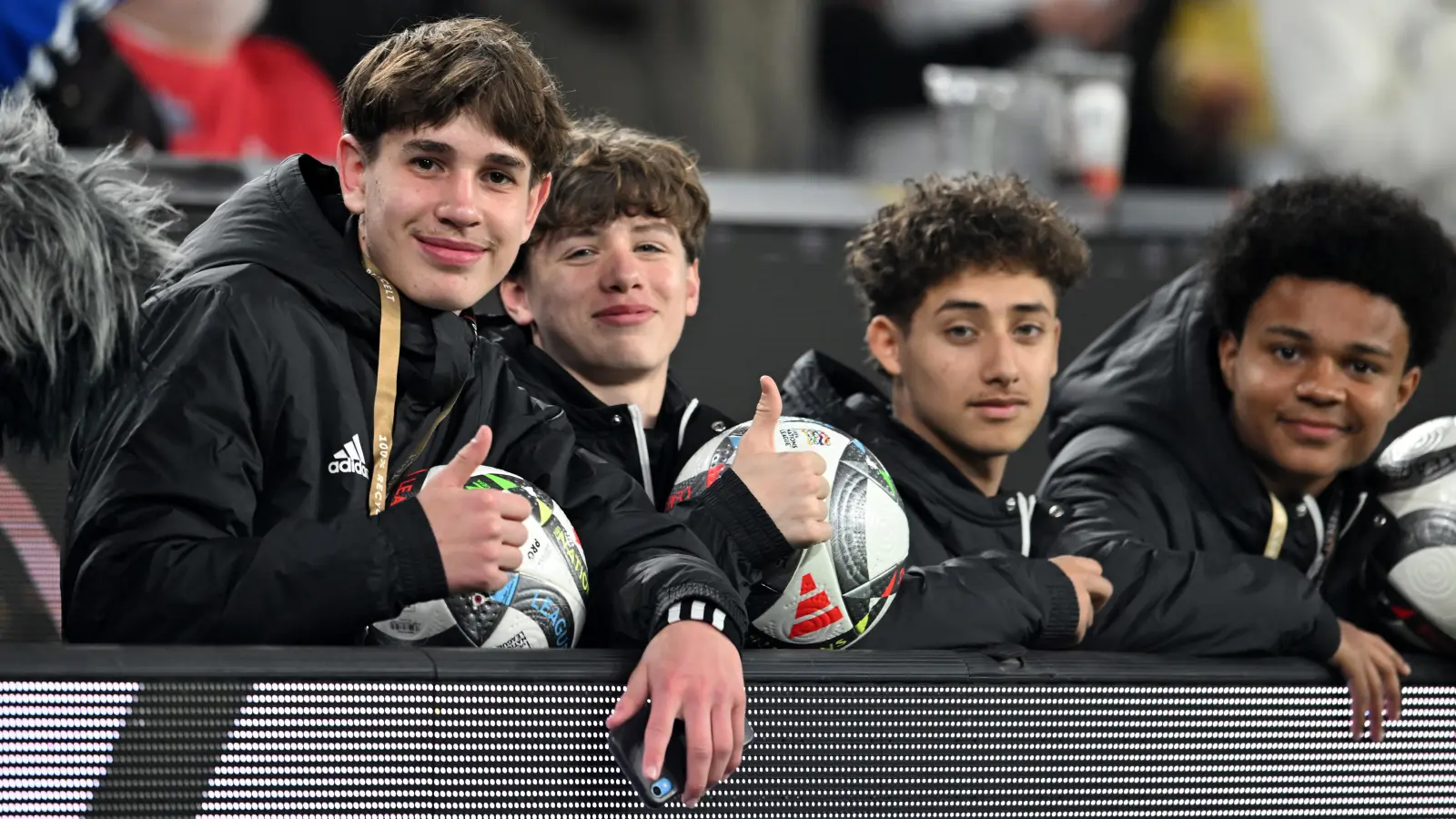 Noel Urbaniak (l) und weitere Balljungen sitzen hinter der Bande. (Bild: Fabian Strauch)
