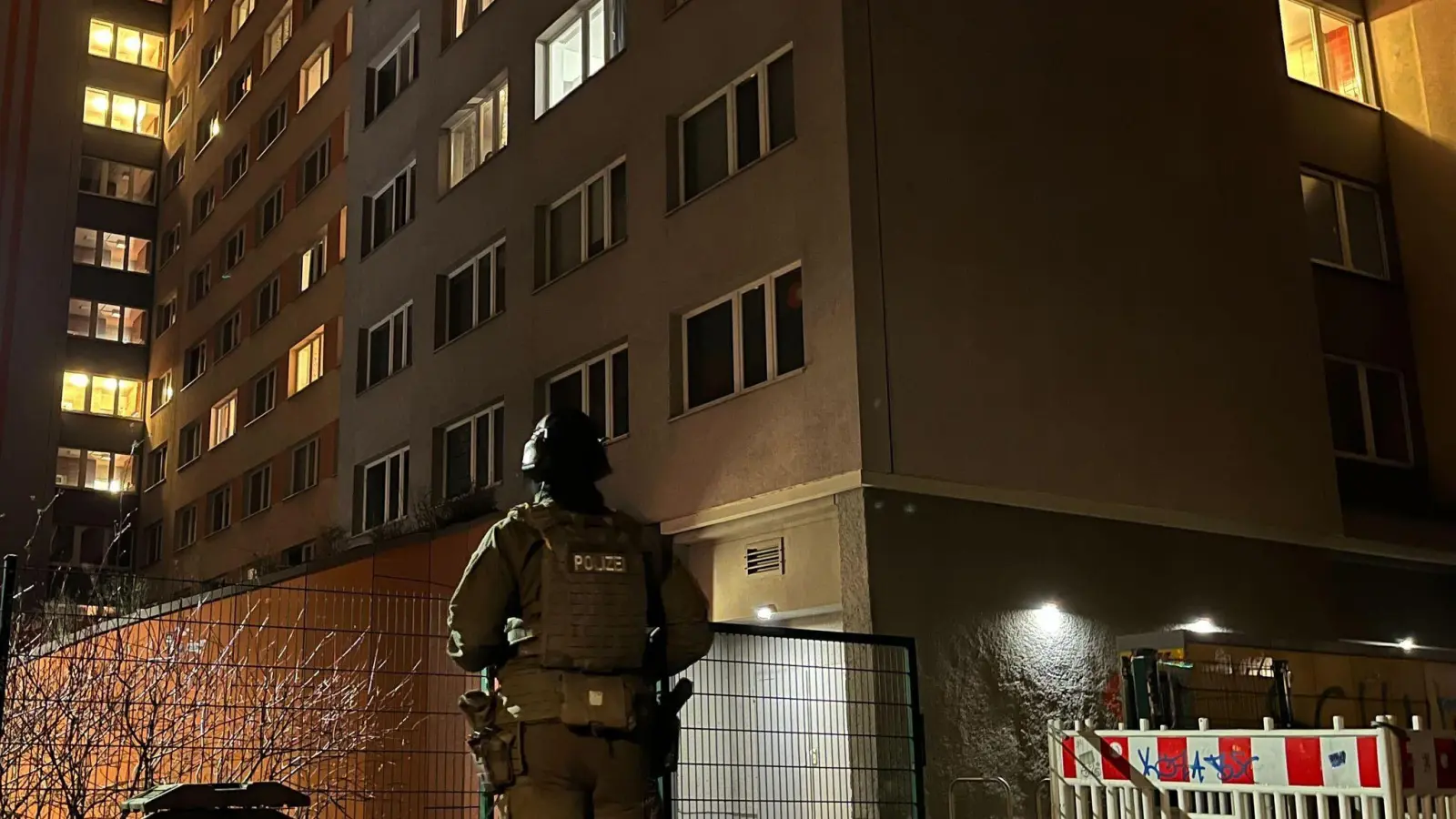 Ein Polizist steht vor dem Studentenwohnheim in Berlin-Friedrichshain, in dem eine Wohnung durchsucht wurde. (Bild: Dominik Totaro/dpa)