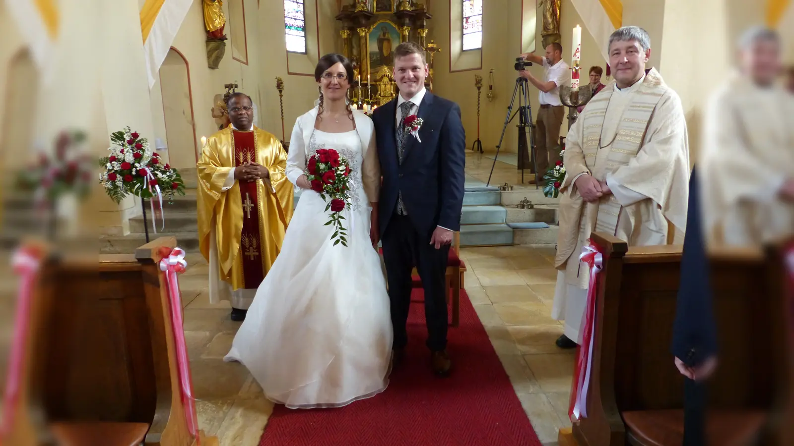 Das frischgetraute Paar Corina und Markus Federl mit den beiden Pfarrern Moses Gudapati (links) und Adam Nieciecki (rechts) in der St. Jakobus Kirche (Bild: sl)