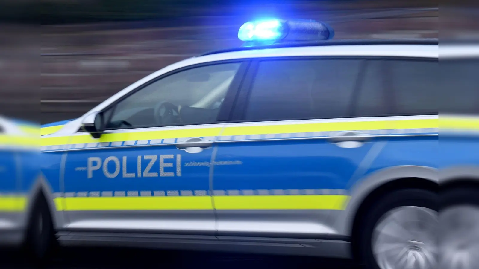 Ein Streifenwagen fährt mit eingeschaltetem Blaulicht. Auf der Kümmersbrucker Kirwa wurde ein Mann mit Pfefferspray attackiert. (Bild: Carsten Rehder/dpa/Symbolbild)