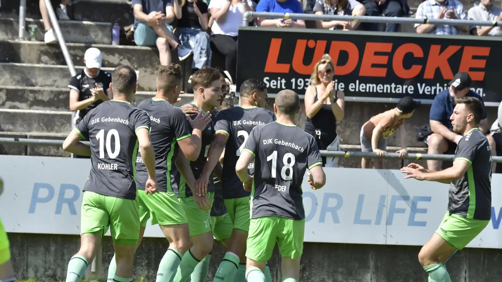 Die Spieler der DJK Gebenbacher bejubeln den 2:1-Heimsieg gegen den Würzburger FV, die Vizemeisterschaft in der Bayernliga Nor und das Ticket für die Regionalliga-Relegation.  (Bild: Hubert Ziegler)