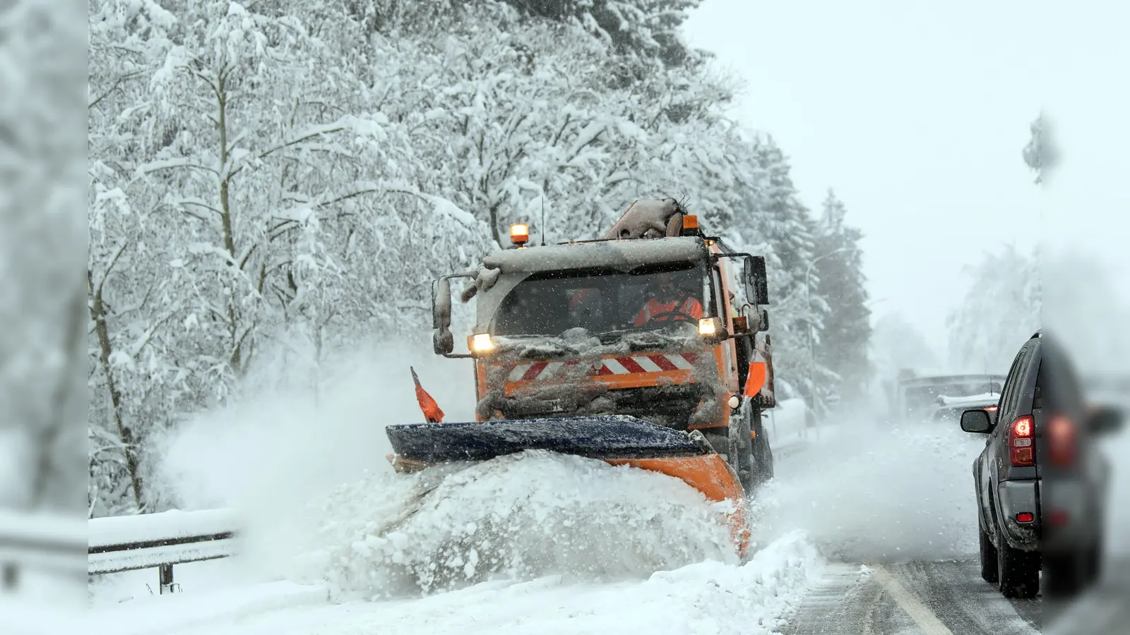 Ein Schneepflug weicht in Hahnbach einem roten Kleinwagen aus und fährt gegen ein Bankgebäude. Die Polizei sucht Zeugen. (Symbolbild: Federico Gambarini/dpa)