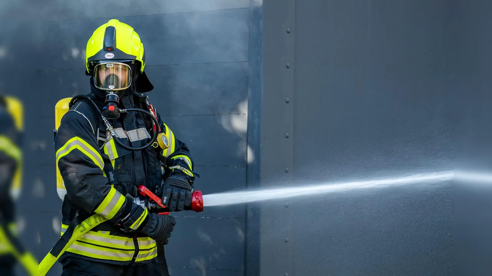 Ein Mitglied der Feuerwehr beim Löscheinsatz. (Symbolbild: David Inderlied/dpa)