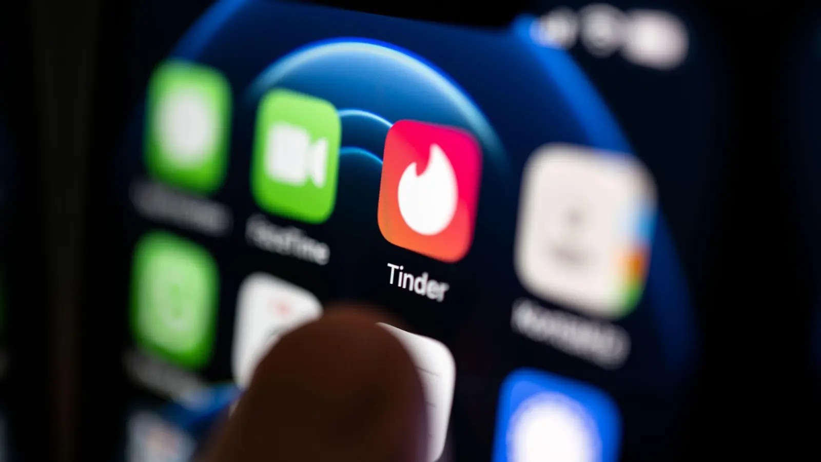 Ein Finger bedient ein Smartphone auf dem unter anderen die App von Tinder installiert ist. (Bild: Marijan Murat/dpa)