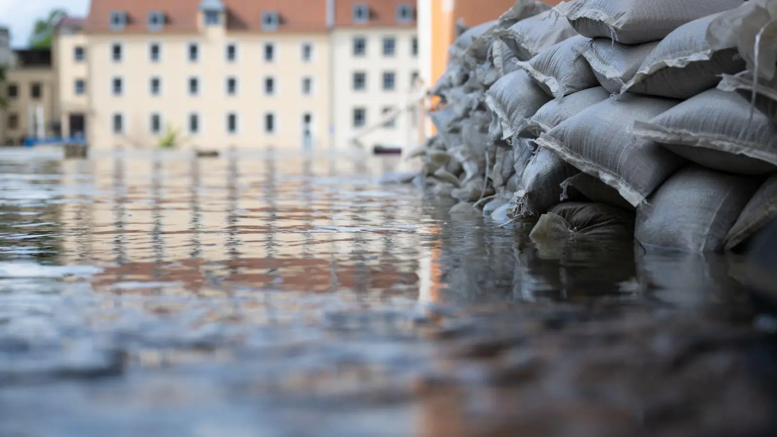 Sandsäcke schützen in der Altstadt am Donauufer die Einfahrt von einer Garage. Seit Tagen kämpfen die Helfer in Bayern gegen die Flut und ihre Folgen. (Bild: Sven Hoppe/dpa)