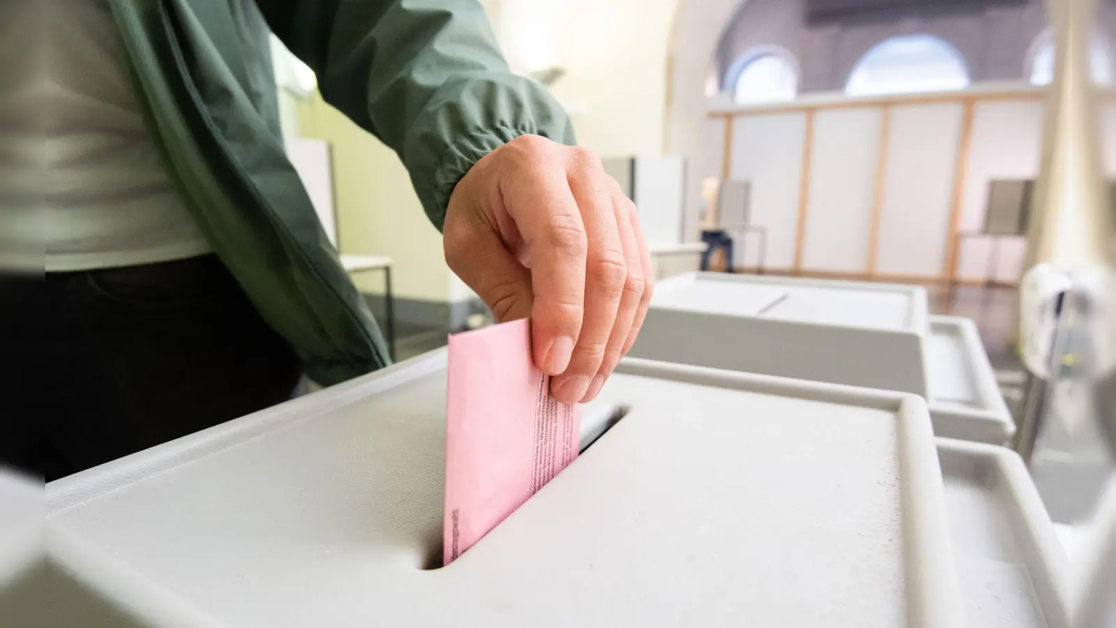 Ein Mann wirft seinen Stimmzettel in eine Urne. (Symbolbild: Julian Stratenschulte/dpa/Symbolbild)