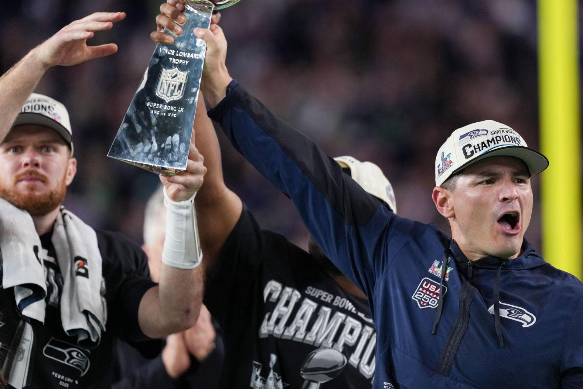 Nur gemeinsam: Trainer MacDonald (rechts) reckt den Pokal mit seinen Spielern Darnold (links) und Walker in die Höhe. (Bild: Matt Slocum/AP/dpa)