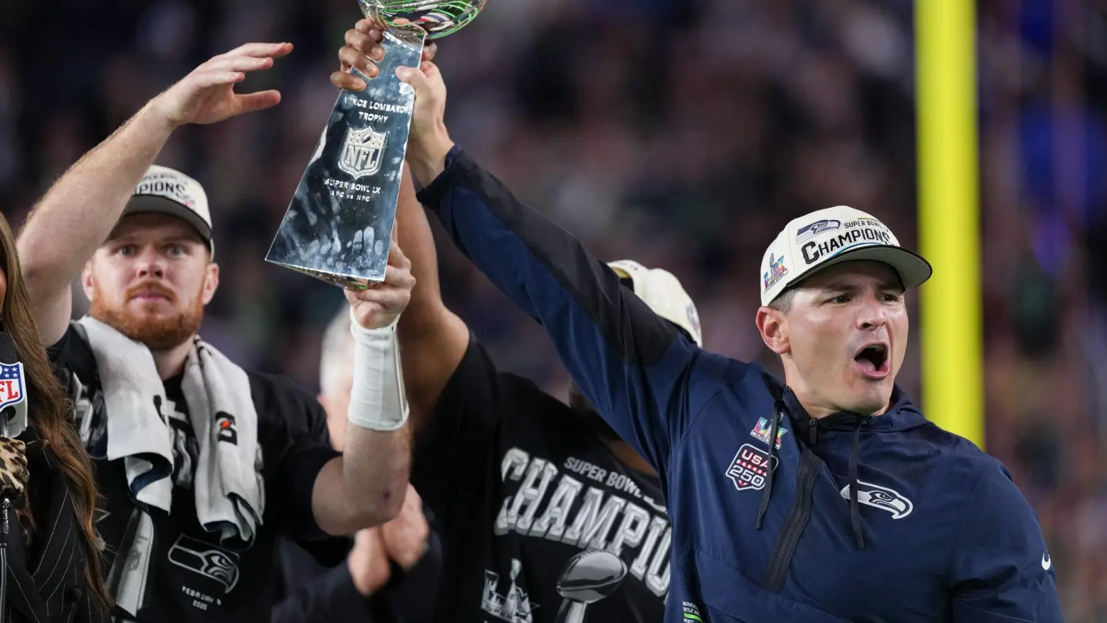 Nur gemeinsam: Trainer MacDonald (rechts) reckt den Pokal mit seinen Spielern Darnold (links) und Walker in die Höhe. (Bild: Matt Slocum/AP/dpa)