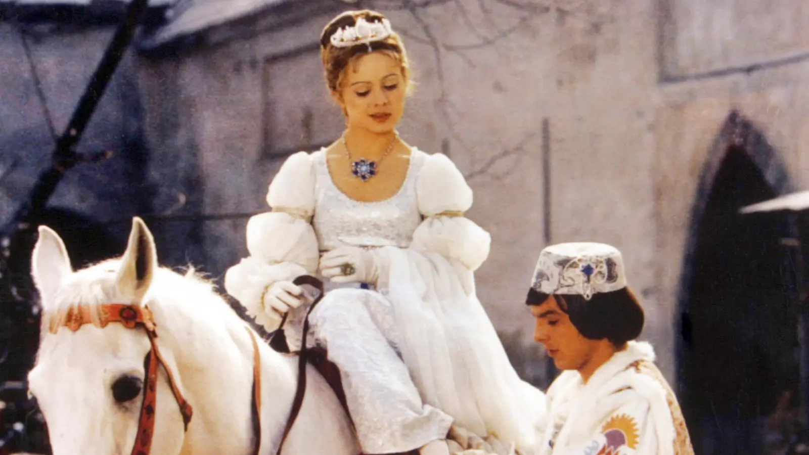 Der Prinz (Pavel Travnicek) passt Aschenbrödel (Libuse Safrankova) im Film „Drei Haselnüsse für Aschenbrödel” den verlorenen Schuh an. (Bild: WDR/Degeto)