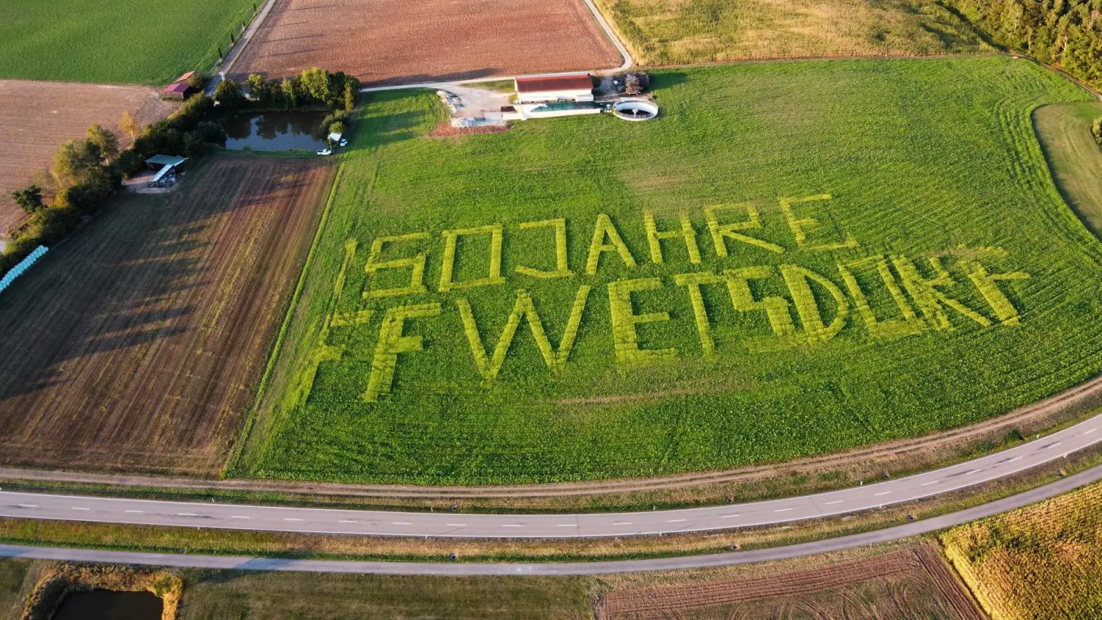 Mit Hilfe von GPS-Technologie säte Feuerwehr-Mitglied Philipp Koch den Schriftzug in ein Feld an der Hauptstraße nach Trisching. Die Buchstaben bestanden aus Senfpflanzen und als Hintergrund diente eine Mischung aus Sonnenblumen und Buchweizen. (Bild: Floian Maiwald/exb)