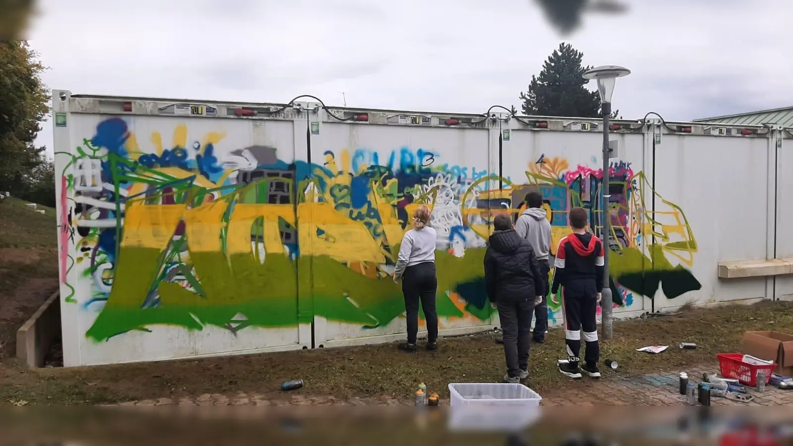 Die Jugendlichen besprühen die Außenwand des Jugendtreffs Cube in Kümmersbruck. (Bild: Leonie Böhnke)