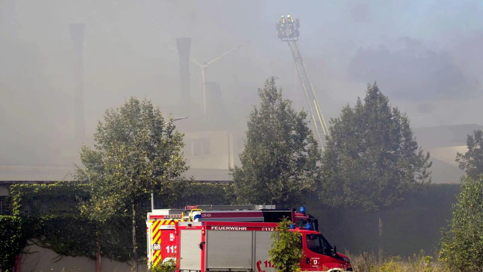 Feuerwehr vor dem Großbrand in dem Industriegebiet von Wunsiedel. Letzte Glutnester müssen noch gelöscht werden. (Bild: Daniel Vogel/-/dpa)