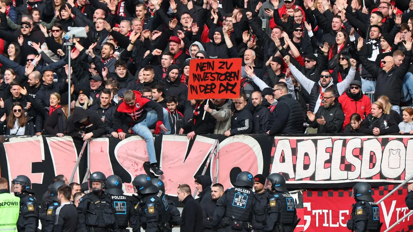 Nürnberger Fans protestieren mit einem Banner am Spielfeldrand gegen Investoren in der DFL. (Bild: Daniel Karmann/dpa)