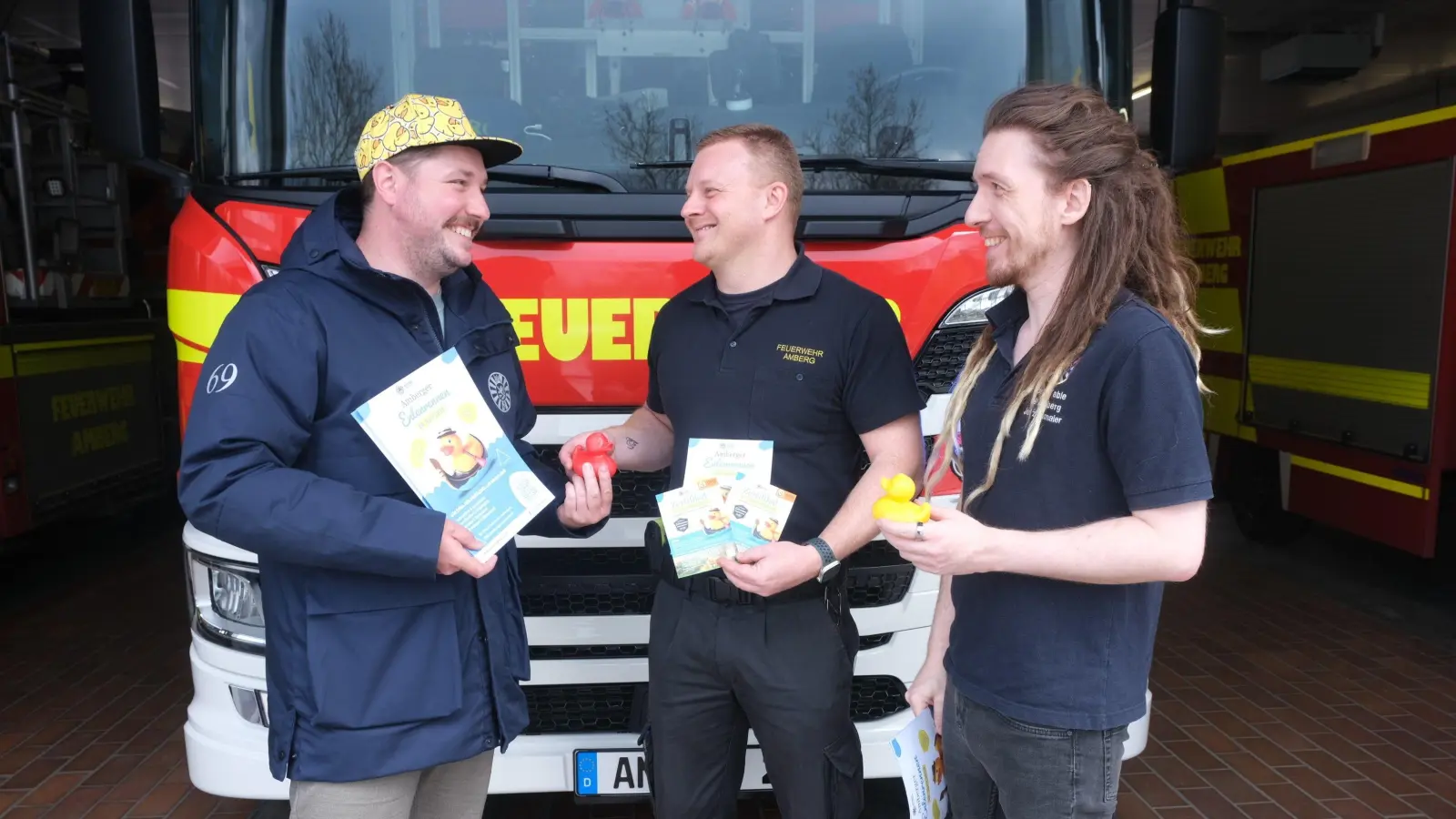 Für langjährige Mithilfe beim Entenrennen bedankte sich Rond Table Amberg bei der Amberger Feuerwehr mit einer roten Ehrenente. Sie geht mit der Notrufnummer 112 ins Rennen. Von links RT-Schatzmeister Stefan Fuchs, Stadtbrandmeister Sebastian Schindler (Mitte) und RT-Webmaster Julian Ellmaier.  (Bild: Hubert Uschald)
