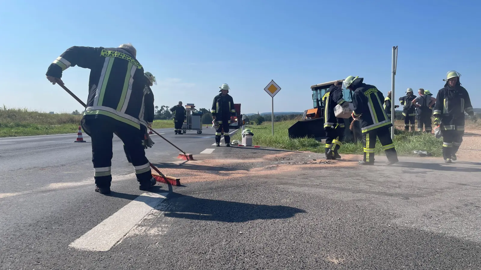 Die Feuerwehrleute kehrten das Bindemittel von der Fahrbahn, bevor sie die Staatsstraße wieder für den Verkehr freigaben.  (Bild: Nils Ganzmann )