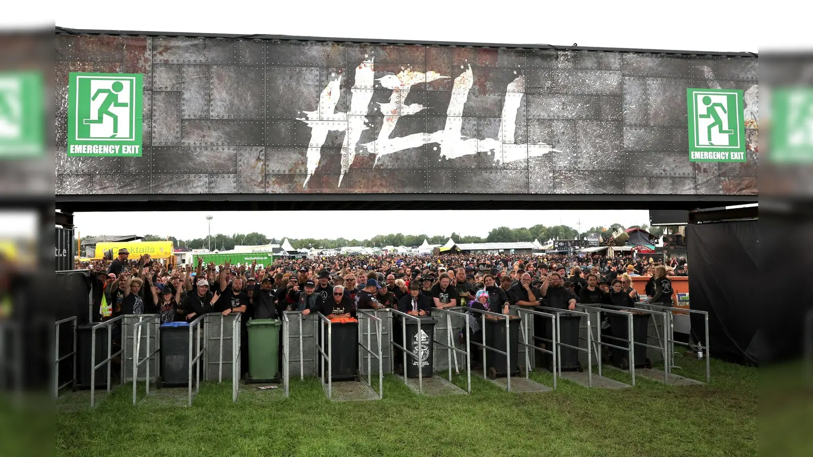 Metal-Fans warten an einem der Eingänge auf die Öffnung des Festivalgeländes. (Bild: Christian Charisius/dpa)