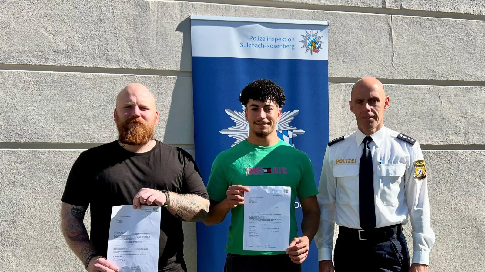 Polizeihauptkommissar Tobias Plößl (rechts), stellvertretender Leiter der Polizeiinspektion Sulzbach-Rosenberg, zeichnet zwei couragierte Bürger aus: Merlin Scharnagl (links) und Abud Alhamad (Mitte) hatten der Polizei geholfen, einen Randalierer im Regionalexpress festzunehmen. (Bild: PI Sulzbach-Rosenberg/exb)