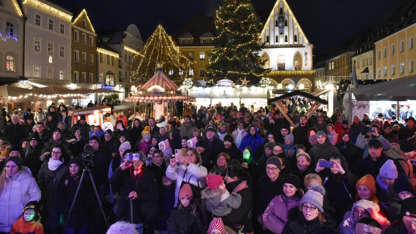 Die Eltern und Verwandten der Kinder aus dem Caritas-Kindergarten Marienheim standen dicht gedrängt am Amberger Weihnachtsmarkt. Im Hintergrund die berühmte Weihnachtsbeleuchtung. (Bild: Stephan Huber)