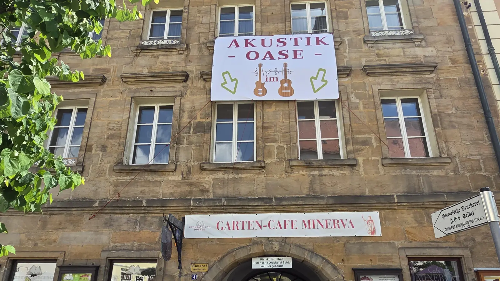 Ein großes Plakat weist schon darauf hin: Der Garten des Café Minerva verwandelt sich am Altstadtfest drei Tage lang in eine Akustik-Oase. (Bild: tgf)
