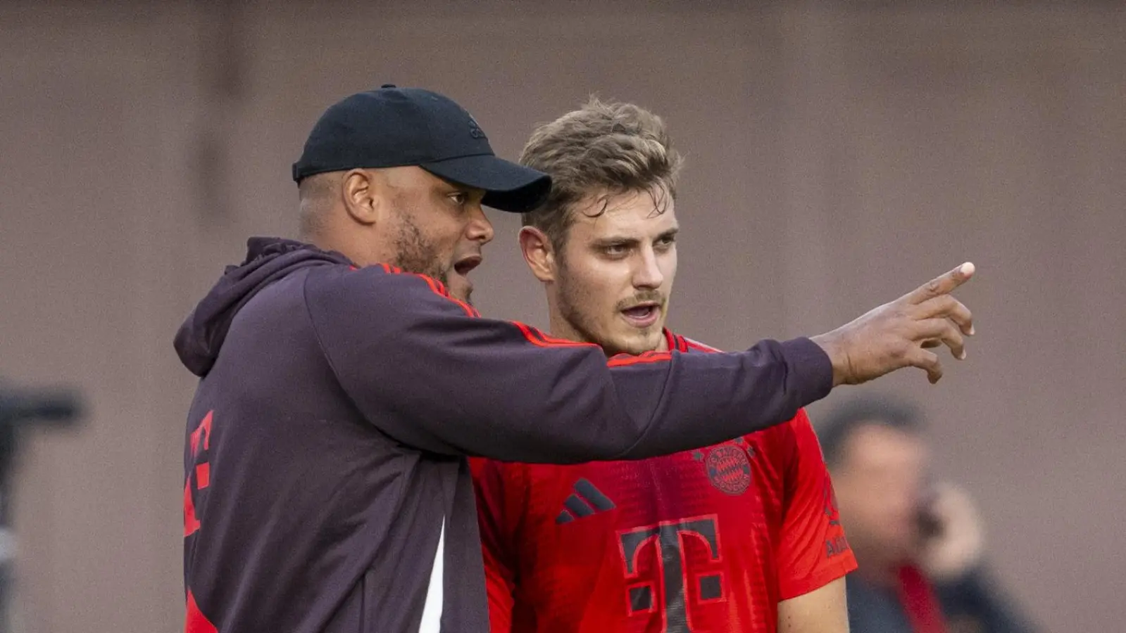 FC-Bayern-Trainer Vincent Kompany (l.) gibt Josip Stanisic Anweisungen.  (Bild: David Inderlied/dpa)