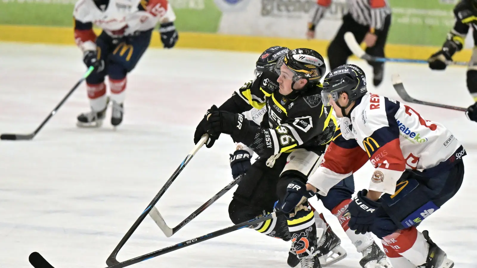 Brendan Walkom (Mitte, Szene aus dem Spiel gegen Ulm) vom ERSC Amberg muss sich hier gegen zwei Gegenspieler durchsetzen. Seine zwei Tore gegen Miesbach reichten am Ende nicht für einen Punktgewinn.  (Bild: Hubert Ziegler)