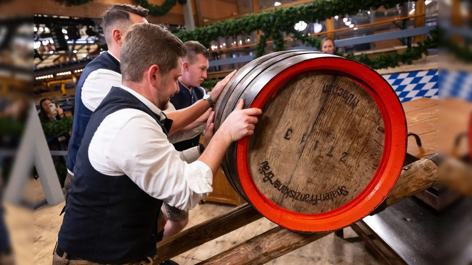 Mitarbeiter rollen beim Münchner Oktoberfest ein Bierfass für den traditionellen Fassanstich in ein Festzelt. In Raigering wurde am Sonntag ein 30-Liter-Holzfass aus dem Sterk-Festzelt geklaut. (Symbolbild: Sven Hoppe/dpa)