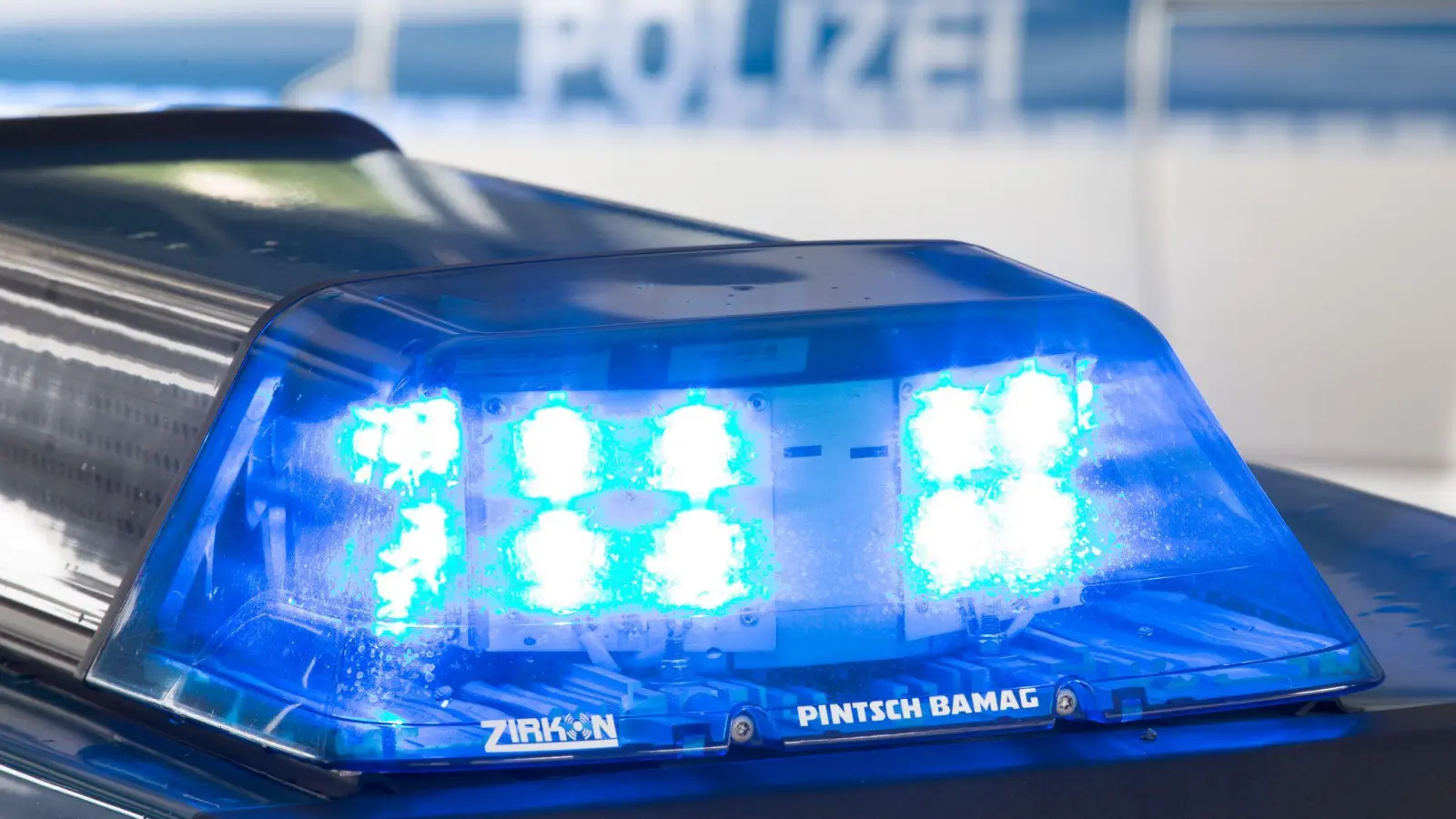 Ein Blaulicht leuchtet auf dem Dach eines Polizeiwagens. (Symbolbild: Friso Gentsch/dpa/)