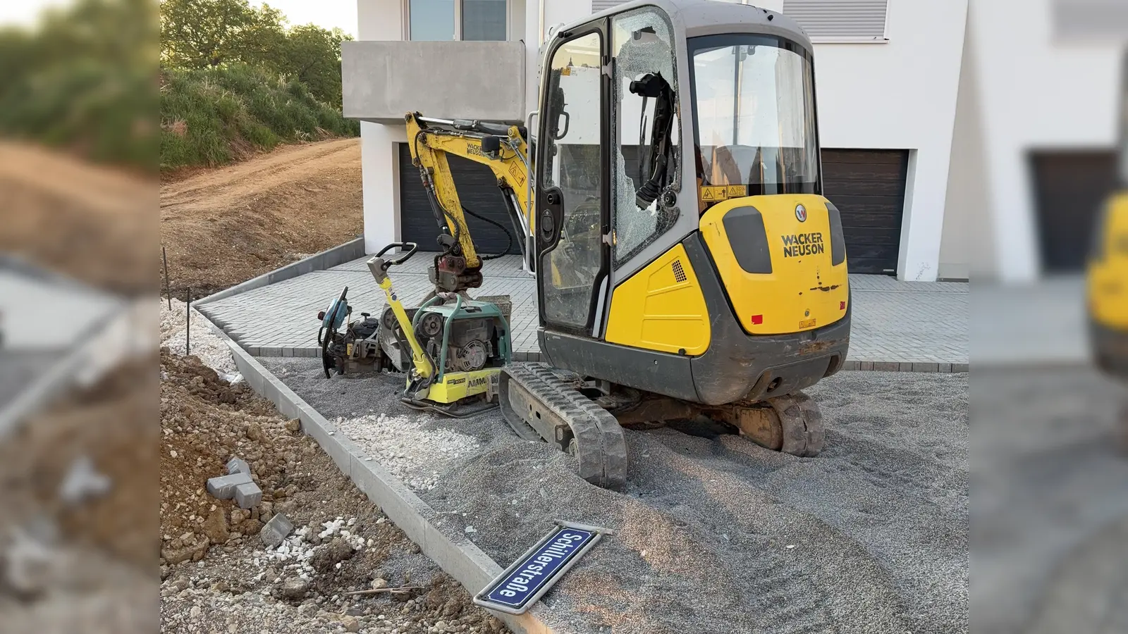 Deutlich ist die zerstörte Scheibe des Minibaggers in Sulzbach-Rosenberg zu sehen. Davor liegt das Tatwerkzeug, ein Straßenschild. (Bild: Polizeiinspektion Sulzbach-Rosenberg)