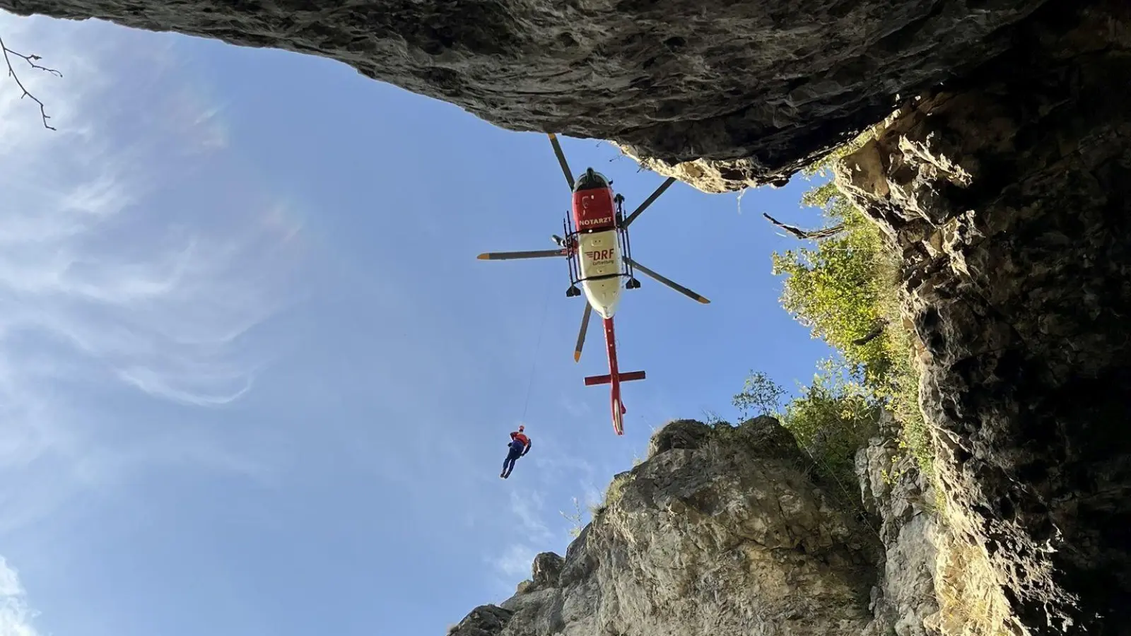 Ein Luftretter der Bergwacht wird an der Rettungswinde zur Einsatzstelle am Hohlen Fels über dem Happurger Stausee abgelassen.  (Bild: Alexander Renner/exb)
