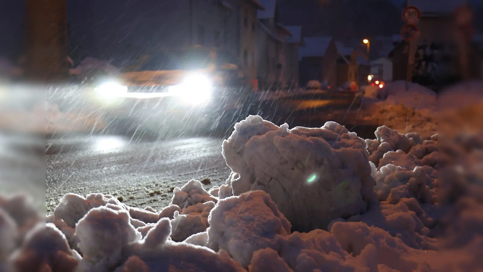 Ein Auto fährt mit Schrittgeschwindigkeit über eine geräumte Straße. Schnee und Glätte haben in Teilen Deutschlands für Unfälle gesorgt. (Bild: Jörg Halisch/dpa)