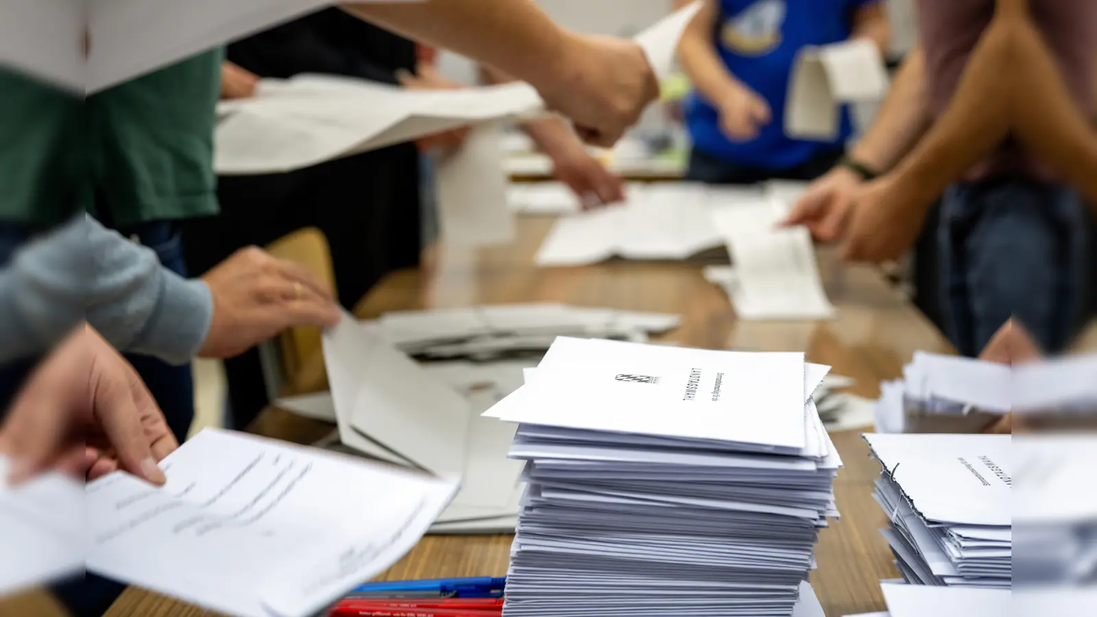 Wahlhelfer zählen die Stimmzettel der Briefwahl aus.  (Bild: Pia Bayer/dpa)
