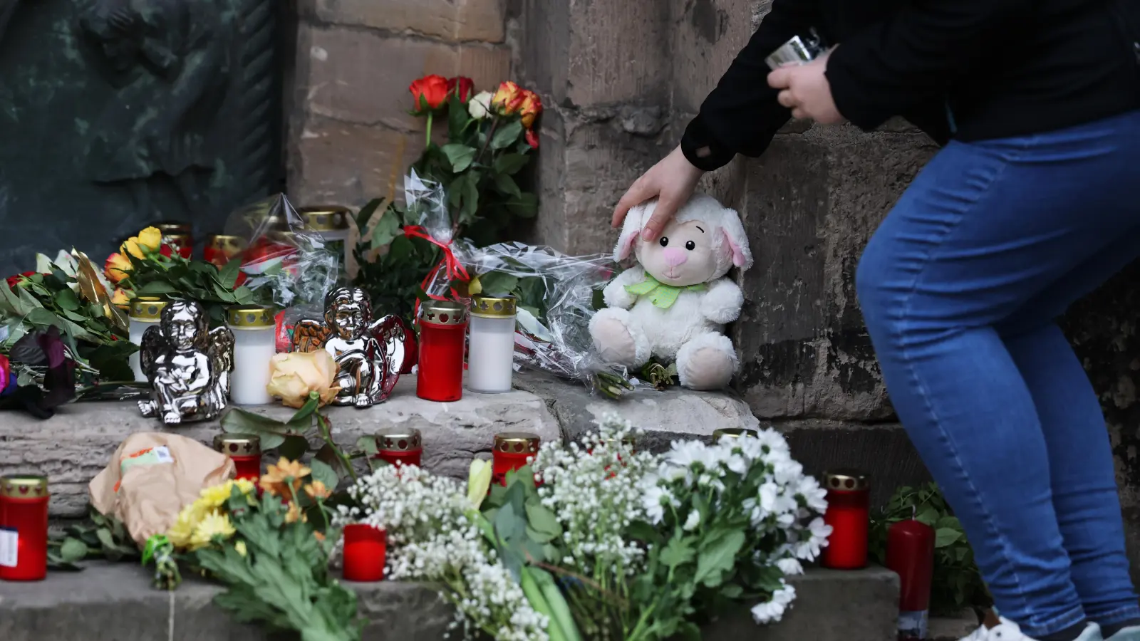 Eine Frau legt am Gedenkort an der Johanniskirche ein Plüschtier nieder. Am Freitagabend ist auf dem Weihnachtsmarkt in Magdeburg ein Autofahrer in eine Menschengruppe gefahren. +++ dpa-Bildfunk +++ (Bild: Jan Woitas /dpa)