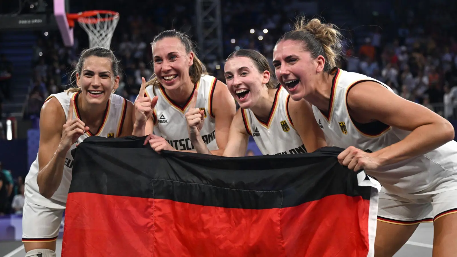 Feiern mit der Fahne: Die 3x3-Basketballerinnen. (Bild: Sina Schuldt/dpa)