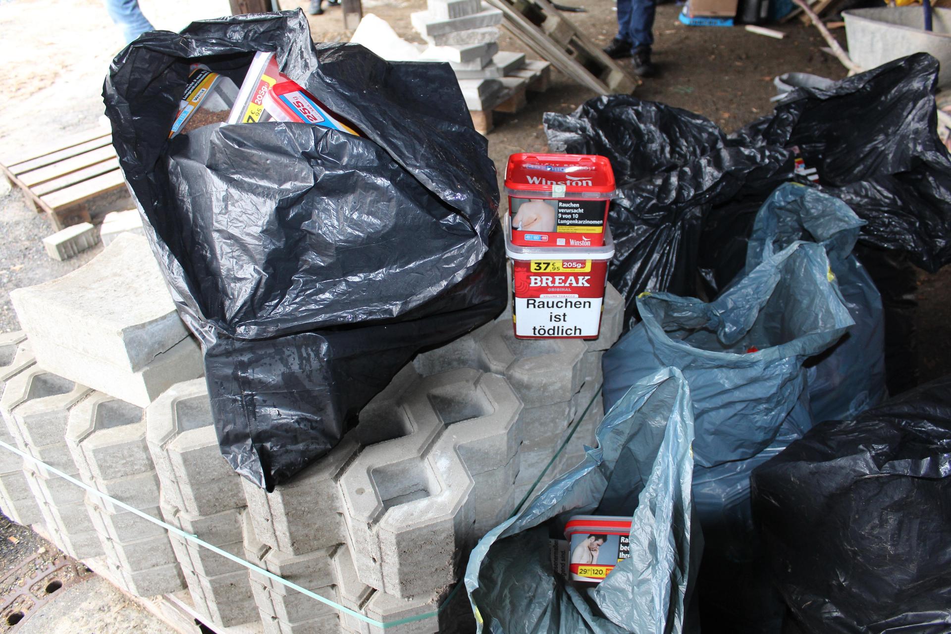Nach der Festnahme der mutmaßliche Einbrecher entdeckten die Polizeibeamten versteckt zwischen Müllcontainern Abfallsäcke mit Tabakwaren, die zum Diebesgut gehören könnten.<br> (Bild: PP OPf)