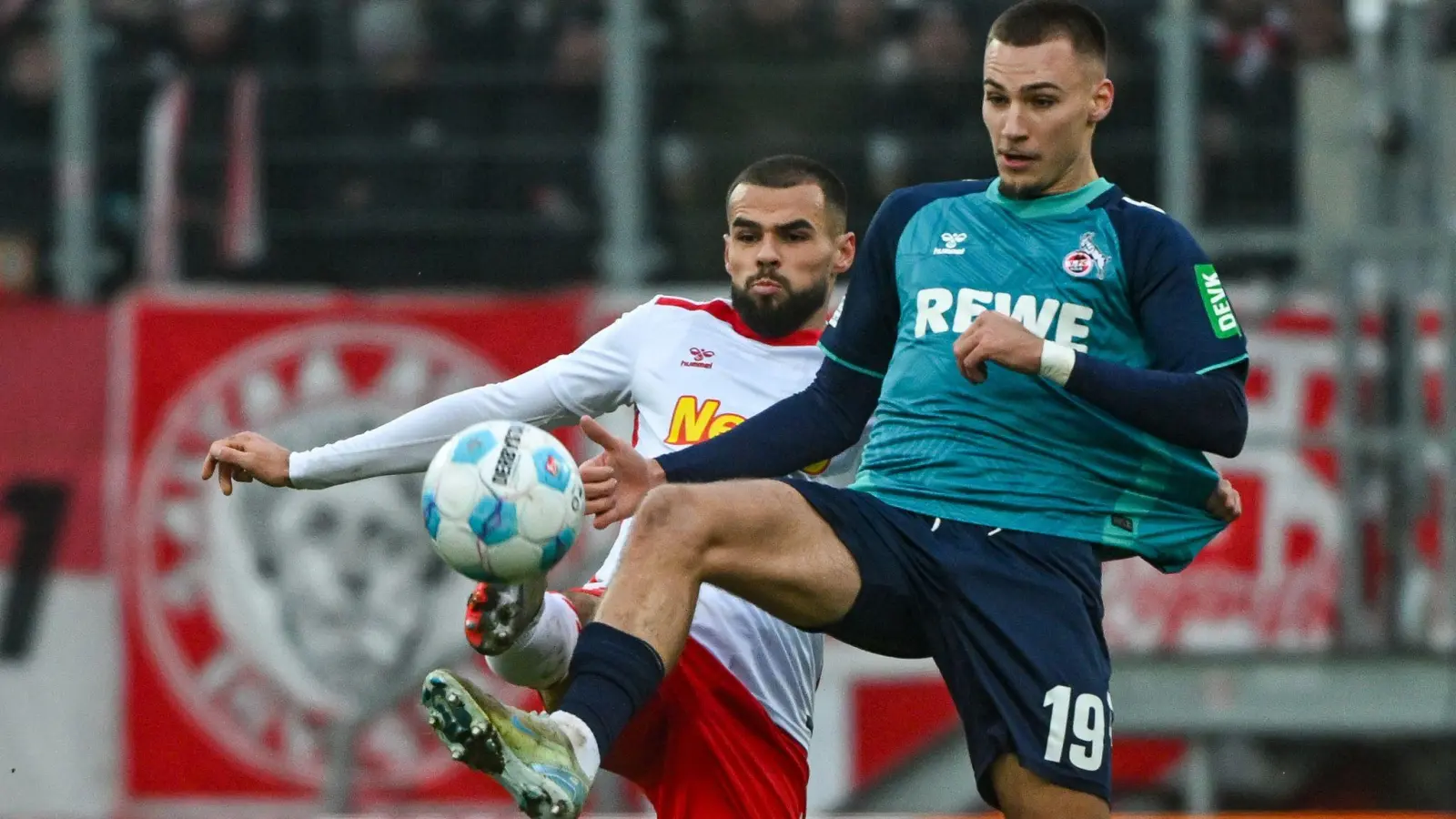 Der Kölner Tim Lemperle (rechts) und Robin Ziegele von Regensburg kämpfen um den Ball. (Bild: Armin Weigel/dpa)