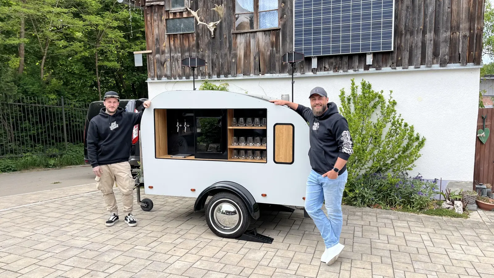 Michl (links) und Martin (rechts) mit ihrer Trailerbar (Mitte). (Bild: knz)