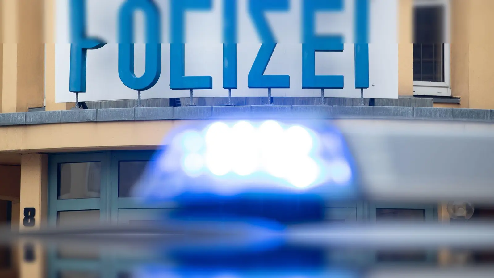 Ein Einsatzwagen der Polizei steht vor einer Dienststelle. (Bild: Friso Gentsch/dpa/Symbolbild)