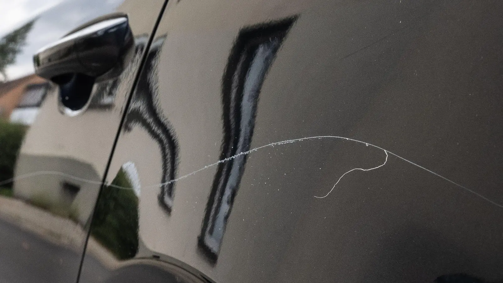Zwar nicht, wie hier auf diesem Symbolbild, am Kotflügel, dafür aber an der Motorhaube und der Frontscheibe hat ein Unbekannter Kratzer an einem Auto in Amberg hinterlassen. (Symbolbild: Swen Pförtner/dpa)