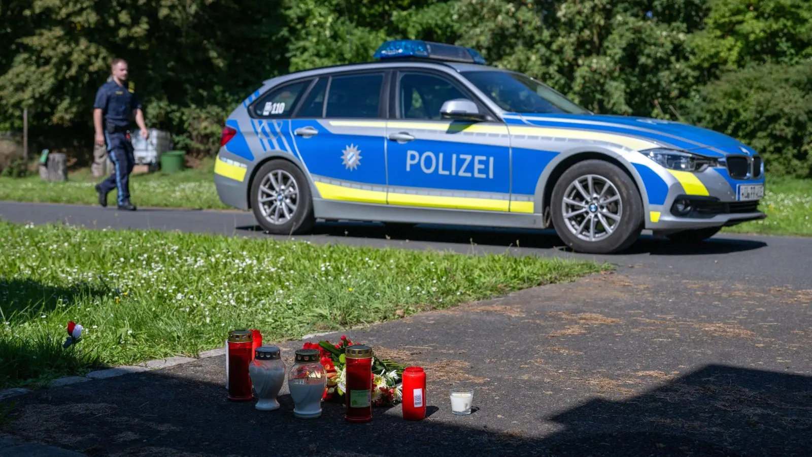 Kerzen und Blumen sind vor einem Seiteneingang des Schulzentrums in Lohr am Main abgelegt. (Bild: Pia Bayer/dpa/Archivbild)