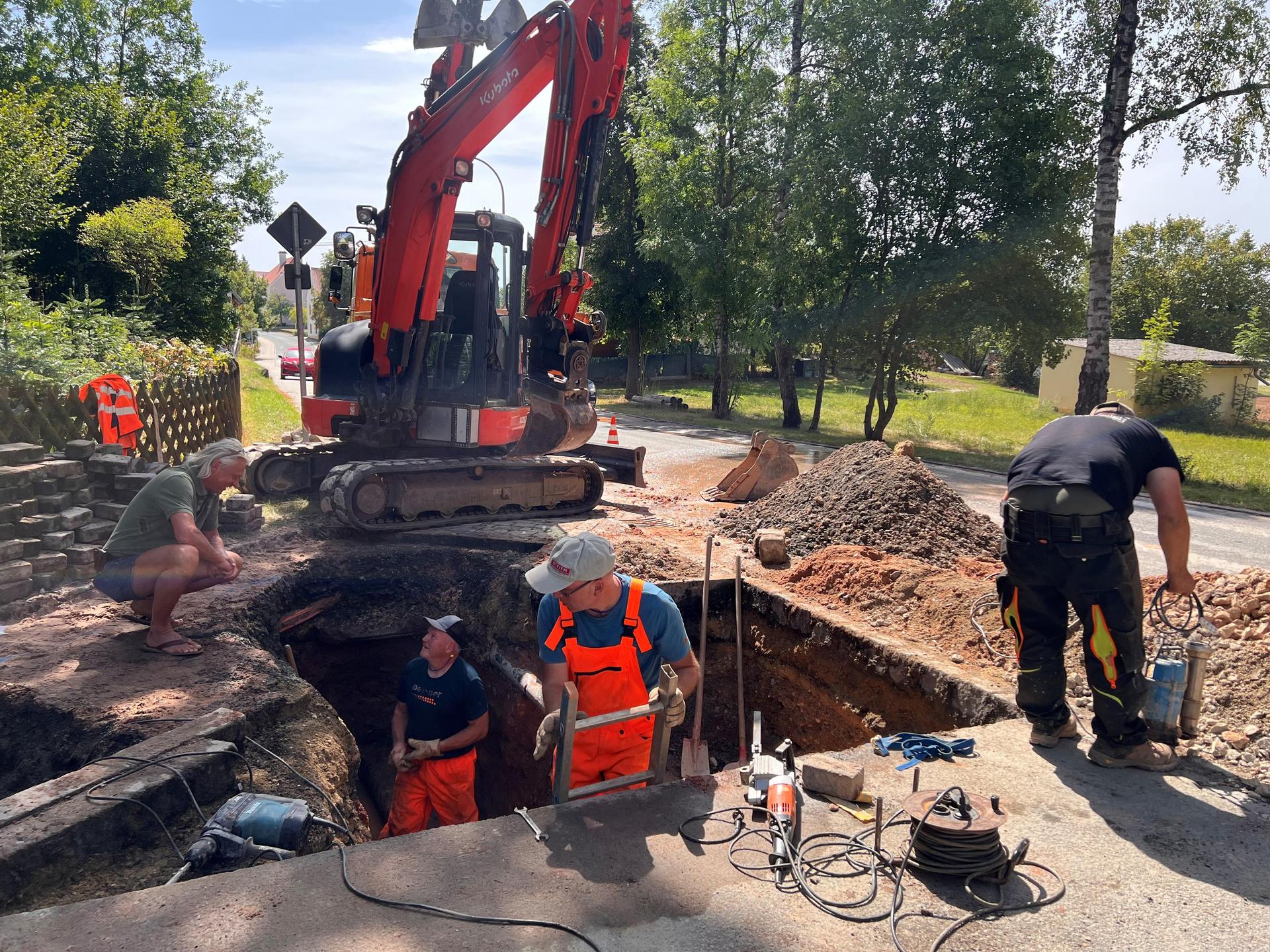 Ursulapoppenricht hat nach einem Wasserrohrbruch in der Nacht zum Donnerstag kein Trinkwasser. Der Mausberger Baggerführer Andreas Wisneth und die Arbeiter vom Hahnbacher Bauhof arbeiten an der Behebung des Schadens. Die defekte alte Leitung versuchen Stefan Pechtl und Joachim Zintl oberirdisch zu sichern und Hans Siegert und Jürgen Lindner arbeiten im Schacht an der Reparatur.  (Bild: Marianne Moosburger)