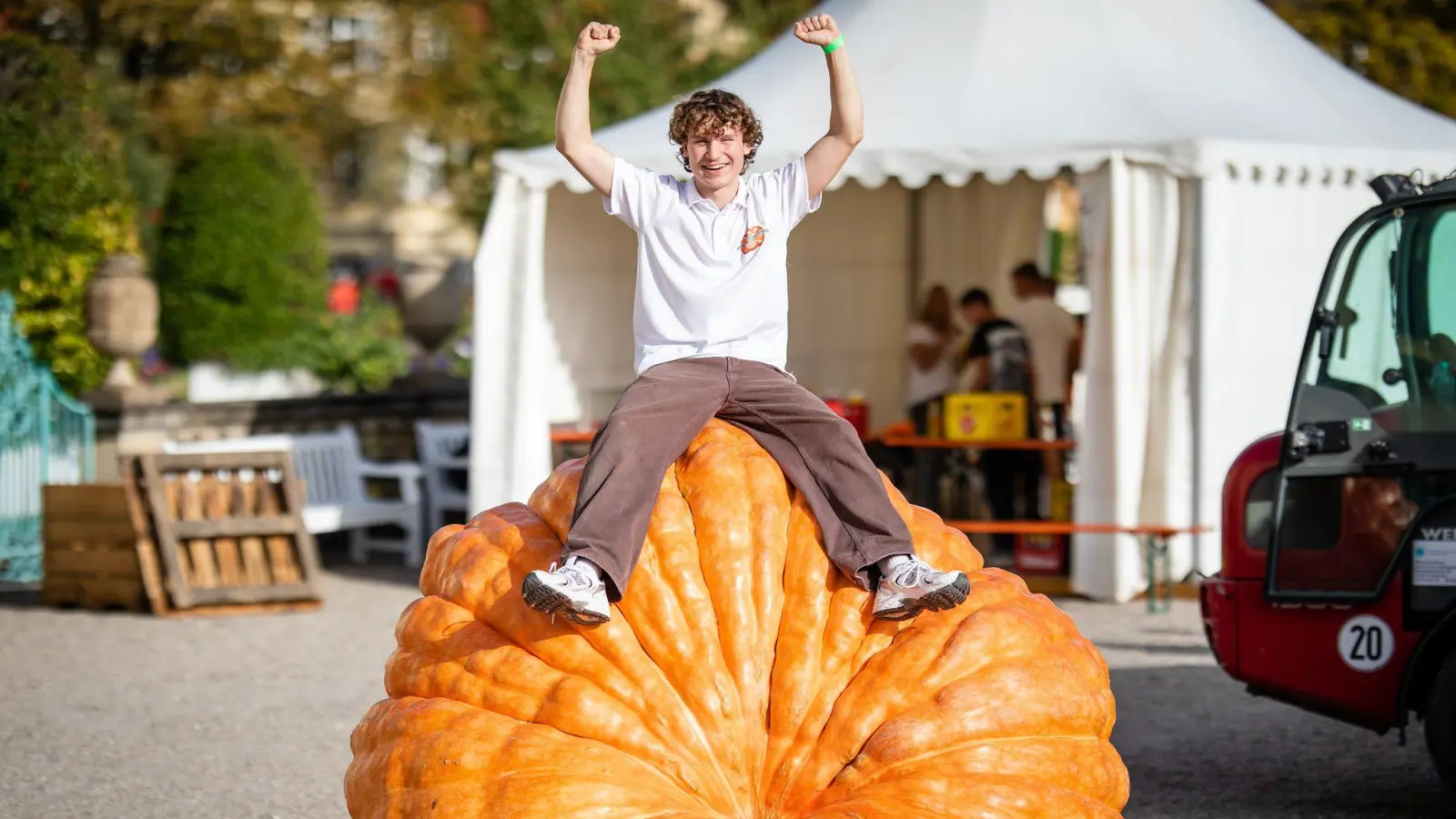 Luca Stöckl (20) sitzt bei der EM im Kürbiswiegen auf seinem 1041,5 Kg schweren Gewinner-Kürbis. (Bild: Christoph Schmidt/dpa)