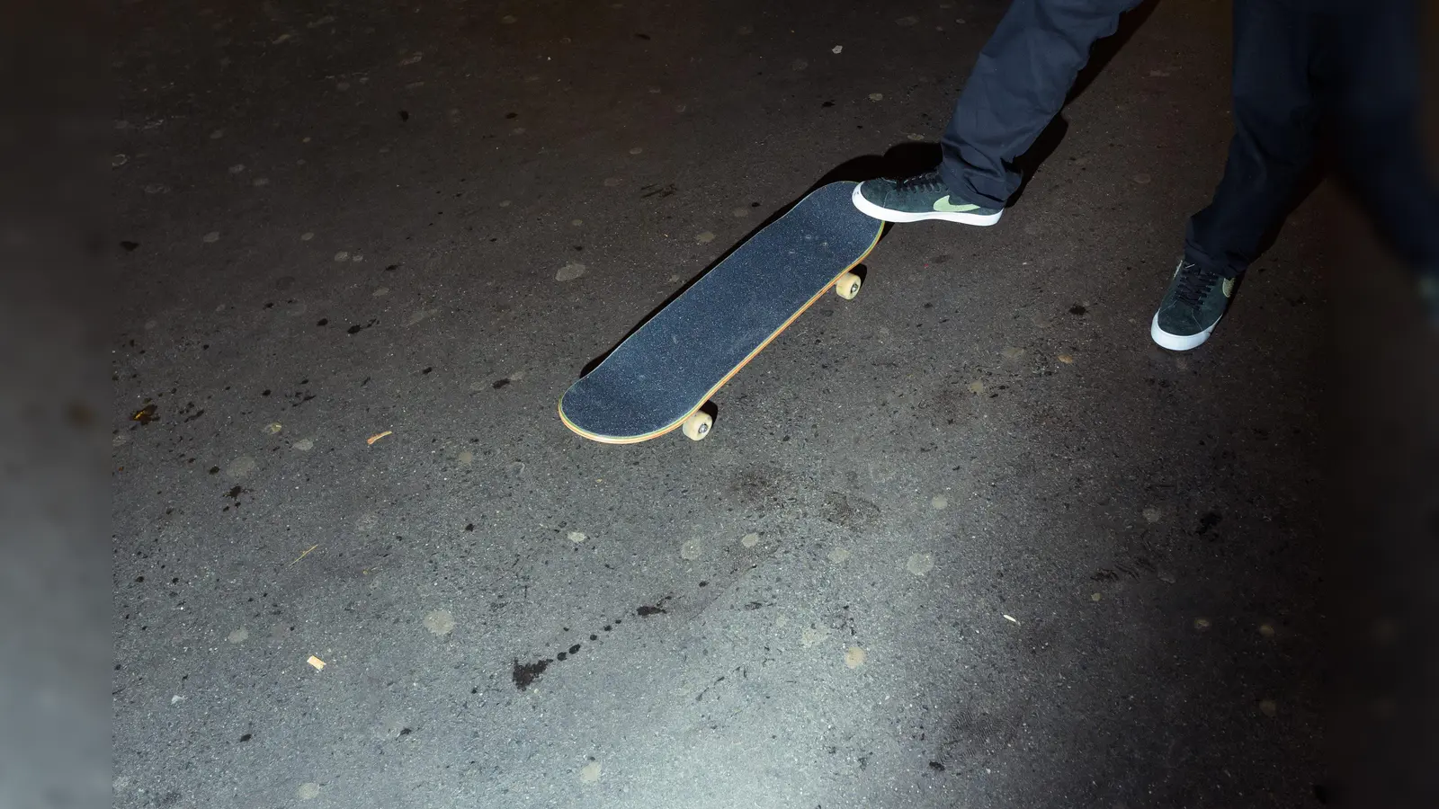 Ein Mann steht mit seinem Fuß auf einem Skateboard. Foto: Gregor Fischer/dpa/Archivbild (Symbolbild: Gregor Fischer)