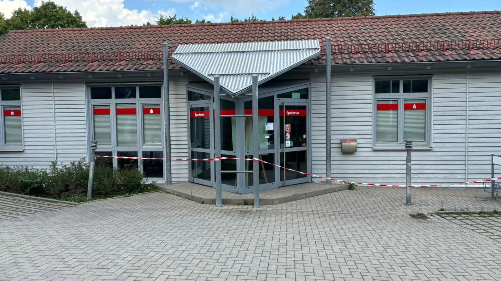 In der Sparkasse in Illschwang haben Unbekannte am Donnerstagmorgen einen Geldautomaten aufgebrochen. Derzeit signalisiert rot-weißes Trassierband, dass die Filiale geschlossen ist. (Bild: san)