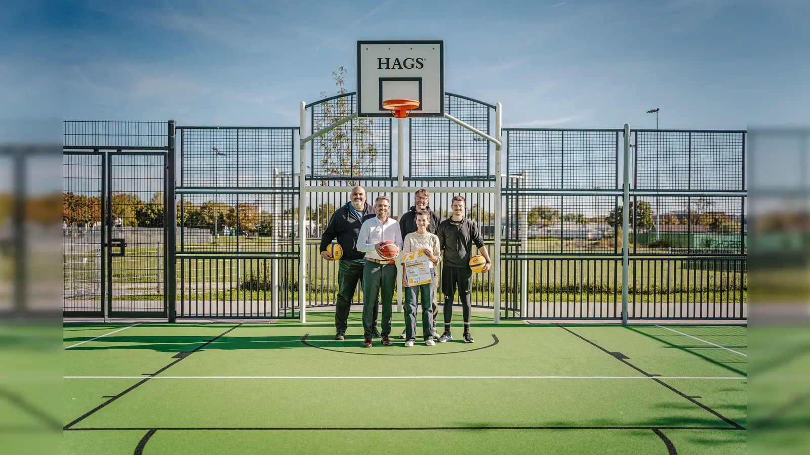 Das neue Multispielfeld im Sportpark am Schanzl bietet jetzt einmal pro Woche ein Gratis-Training für Jugendliche Basketballer an. Oberbürgermeister Michael Fritz (vorne links) durfte sich bei der Vorstellung am Basketball versuchen.  (Bild: Michael Golinski)