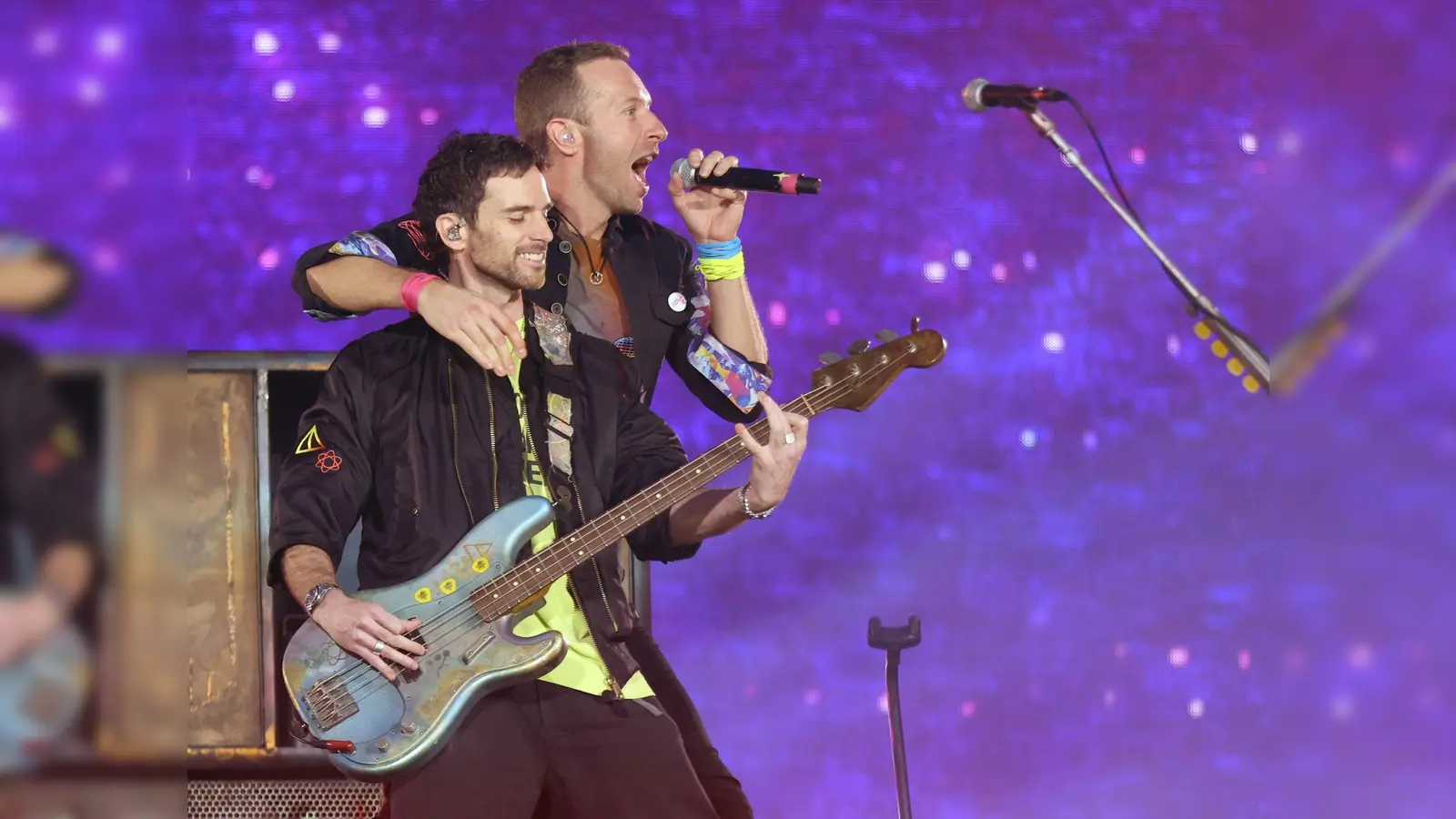 Chris Martin (oben), Sänger von Coldplay umarmt Guy Berryman, den Bassisten der Band, während der „Music of the Spheres”-Tour auf der Bühne. (Bild: Suzan Moore/PA Wire/dpa/Archivbild)