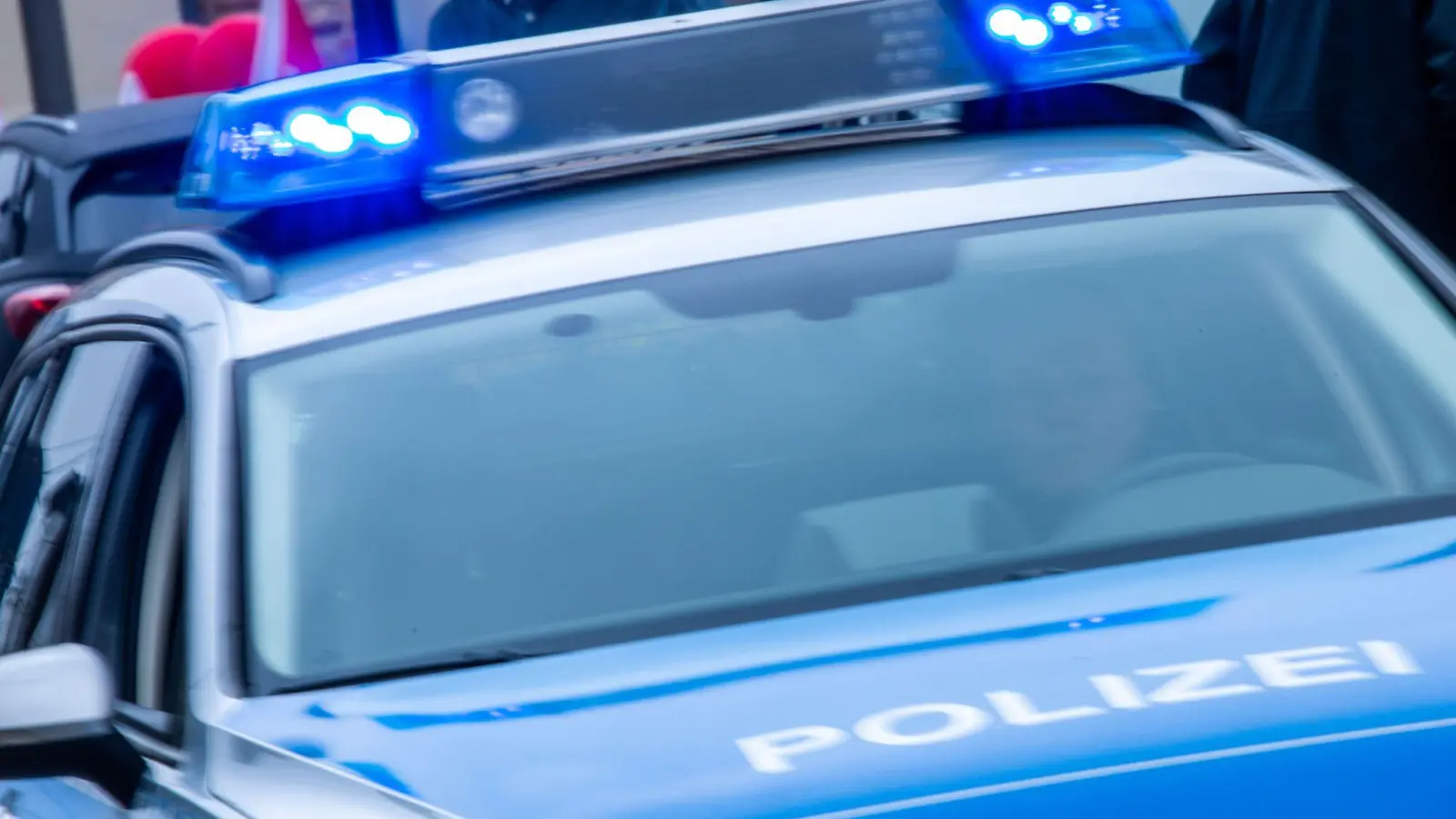 Ein Streifenwagen der Polizei ist mit Blaulicht im Einsatz. (Bild: Jens Büttner/dpa/Symbolbild)
