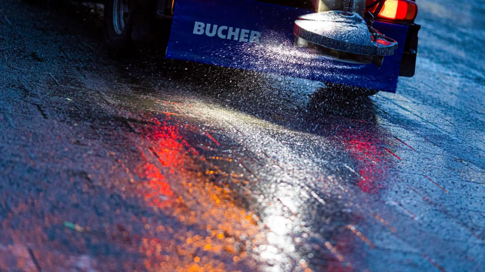 Ein Streufahrzeug verteilt Streumittel auf der Straße. Am Donnerstagabend könnte es in der Oberpfalz Glatt werden. (Symbolbild: Moritz Frankenberg/dpa)