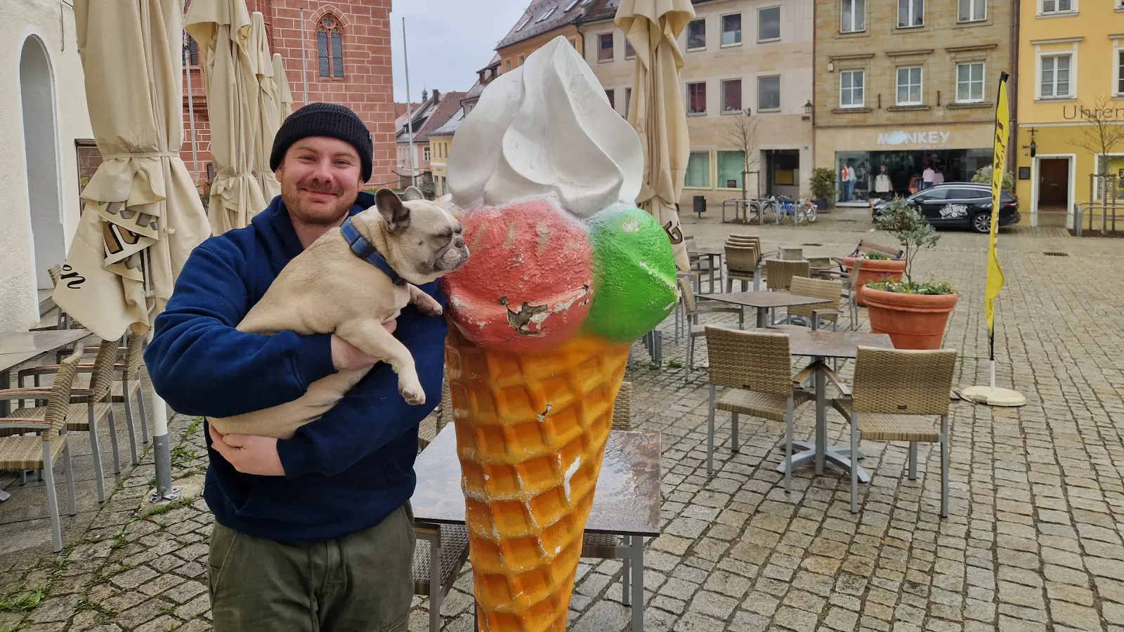 Wenn schon ständig Leute für ein Selfie kommen, muss der „Chef” auch mal auf ein Foto mit „Sulzbachs berühmtester Eistüte”: Wirt Tim Biersack, mit seiner französischen Dogge Heidi, freut sich, dass sein geklauter Werbeaufsteller wieder da ist. (Bild: Tobias Gräf)