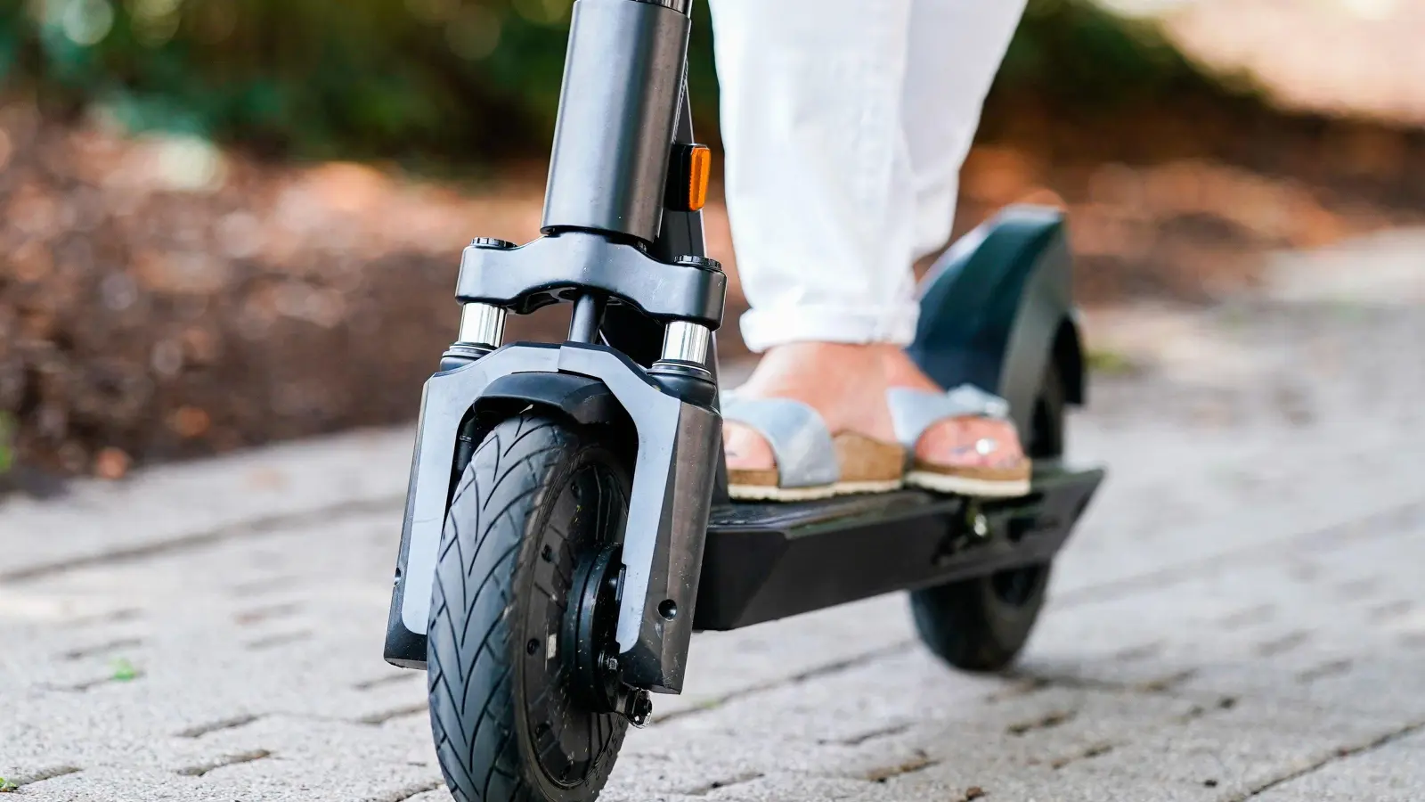 Eine Frau fährt einen E-Scooter. In Amberg ist eine 53-Jährige mit so einem Elektro-Roller gestürzt.  (Symbolbild: Uwe Anspach/dpa)
